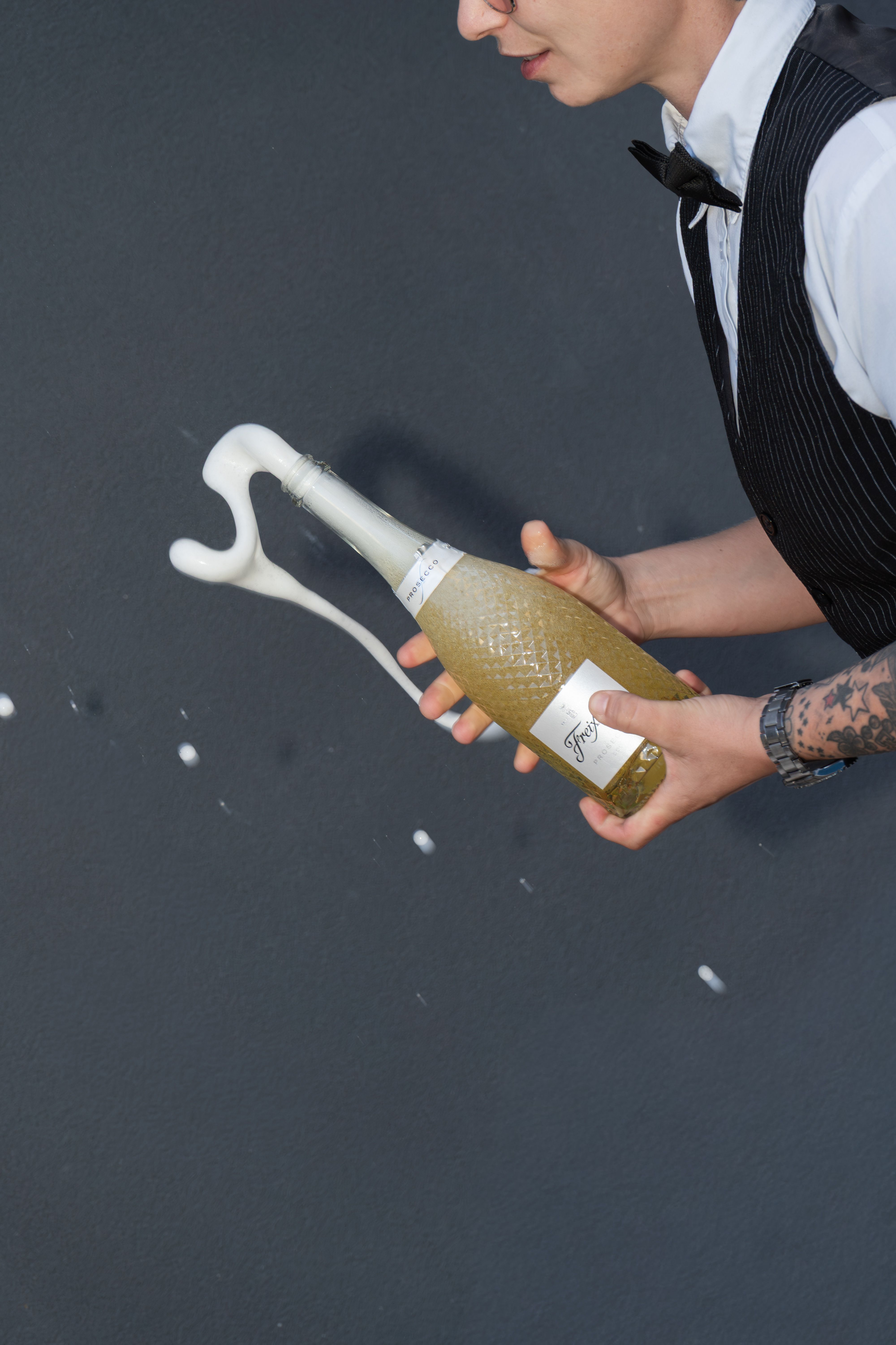 Waiter pouring prosecco at a 26 Suites event